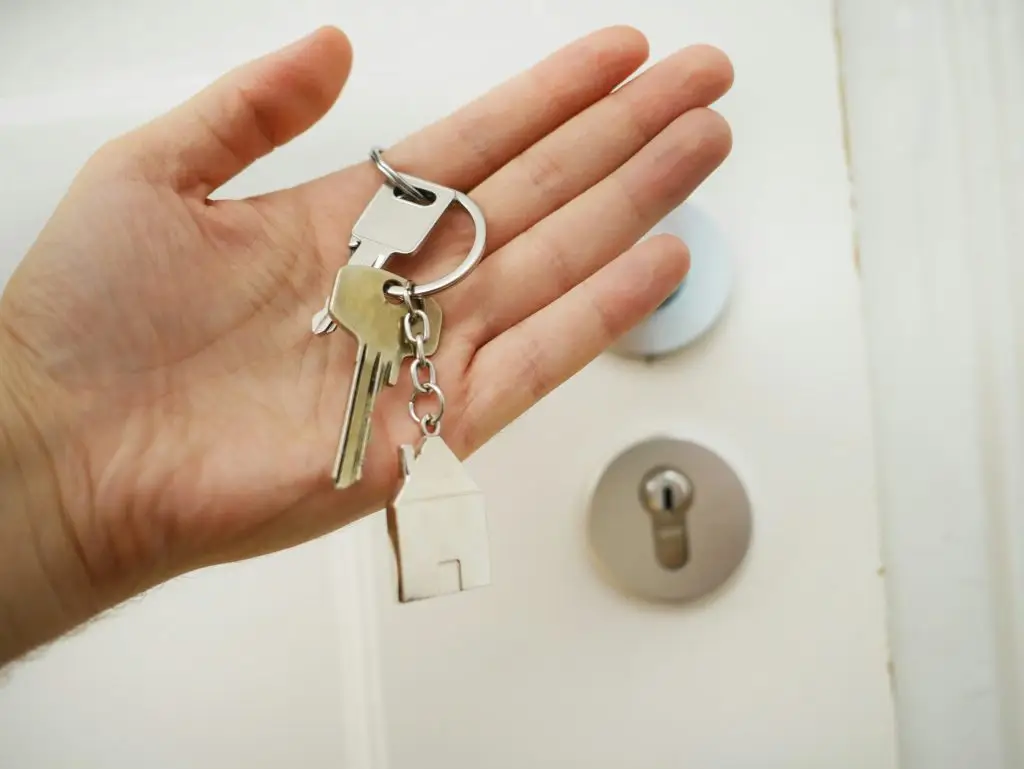 A-locksmith-displays-a-key-and-house-keyring-in-their-hand.